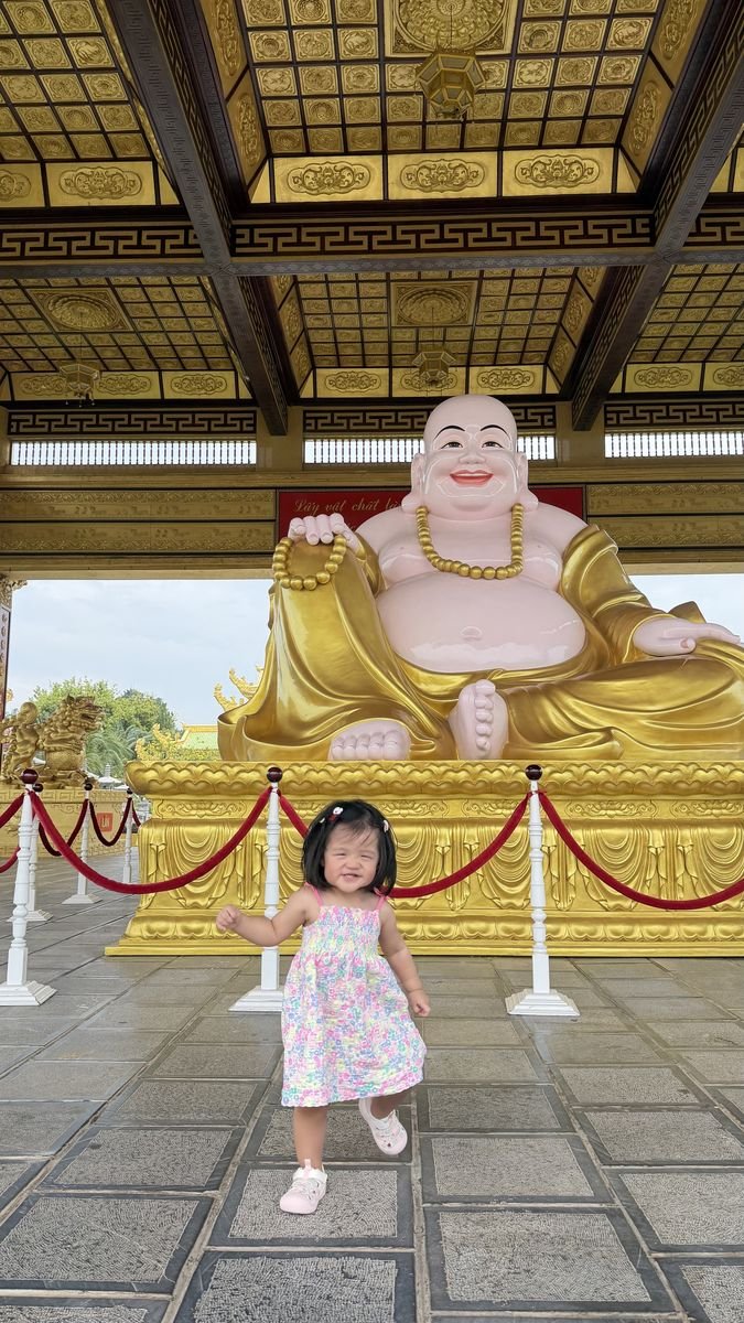 Bé đứng trước tượng Phật Di Lặc tại Đại Nam